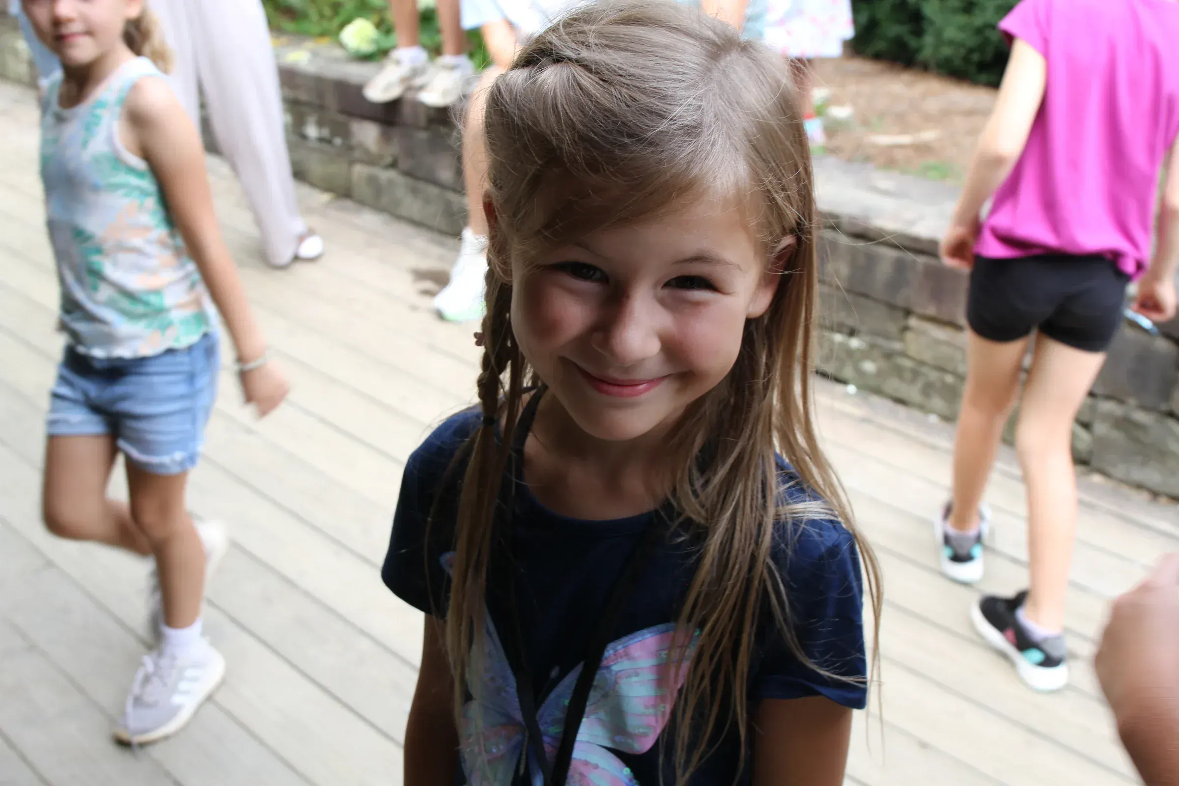 A camper smiles warmly at the camera during an afternoon activity.
